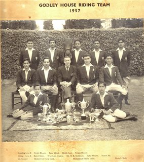1957 - The 1957 Godley House Riding Team with Mr. Goldstein. Standing (L to R): Shoket Husain, Fazal Mohd, Mohd Asad, Tauqir Husain. Sitting (L to R): Kamil Khan, Wajid Ali (Captain), Mr. R. K. Goldstein, Iqbal Husain, Nusrat Ali. On Ground: Muhammad Tariq Malik, Muhammad Khalid Malik.
